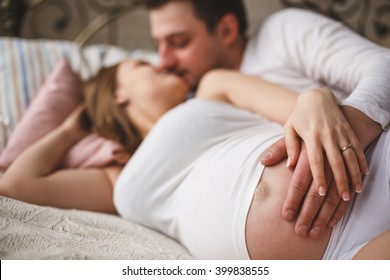 Loving pregnant couple kiss 
