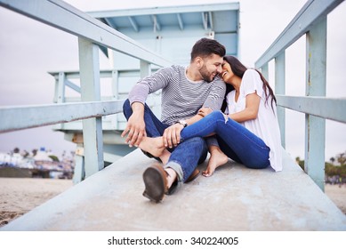 loving romantic Hispanic couple snuggling with each other near santa monica shot with selective focus