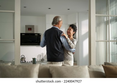 loving romantic senior asian couple dancing in living room at home - Powered by Shutterstock