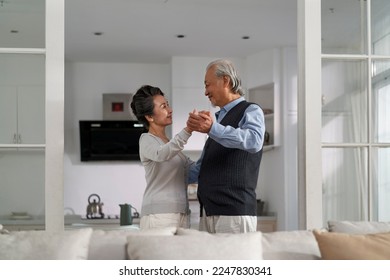 loving romantic senior asian couple dancing in living room at home - Powered by Shutterstock