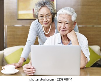 loving senior asian couple using a laptop computer together.
