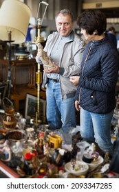 Loving Senior Couple Choosing Vintage Goods At Flea Market