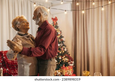 A loving senior couple is dancing at cozy home on christmas and new year's eve. - Powered by Shutterstock