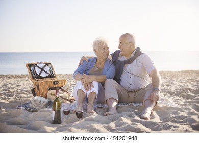 Loving Senior Couple Having Romantic Picnic On The Beach