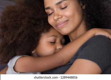Loving single black mother hugs cute daughter feel tenderness connection, happy african mum caressing embracing little girl, mommy kid cuddle, warm relationships, child custody, foster care concept - Shutterstock ID 1289448856