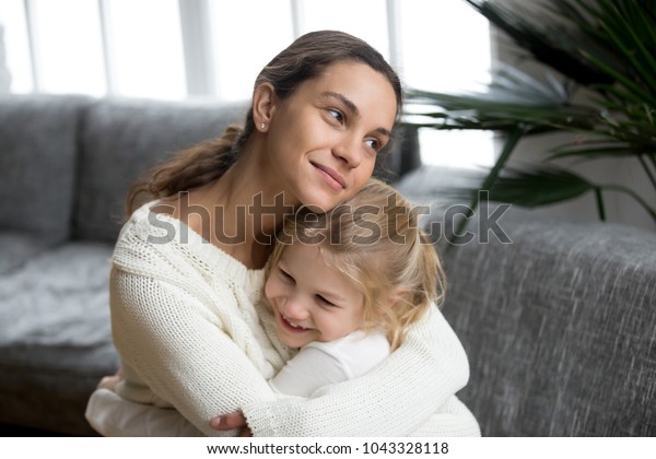 未婚の母親が愛情を示す可愛い小さな娘を抱きしめ 家で未就学児を抱きしめる幸せな女性 母と子どもの心の温かい関係 養子のコンセプトに新しい母親 の写真素材 今すぐ編集