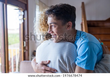 Loving teenager smiling enjoy moment strong cuddles adult mom after long separation, mother glad to see son multi generational family reunion, love and bonding concept