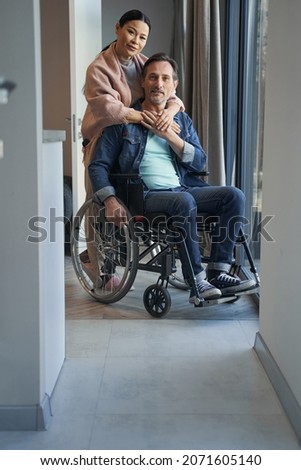 Similar – Caregiver with elderly patient in a wheelchair in front of window