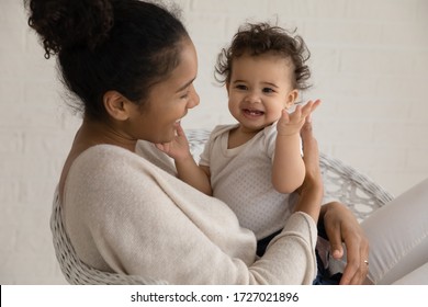 Loving Young African American Mother Hold Embrace Cute Little Ethnic Infant Toddler, Caring Biracial Mom Play Have Fun Hug Small Baby Child, Enjoy Family Time At Home Together, Childcare Concept