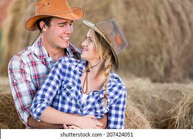 Loving Young American Western Couple Hugging In Barn