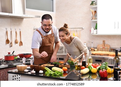 Loving Young Asian Couple Cooking In Kitchen Making Healthy Food Together Feeling Fun