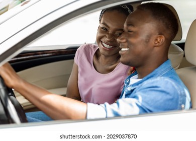 Loving Young Black Man And Woman Sitting Inside New Auto, Having Conversation And Laughing, Having Summer Car Trip To Countryside, Happy African American Couple Enjoying Weekend Together, Side View