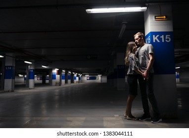 Loving young couple having fun and hugging in underground parking. Parking garage. Family have fun in the parking lot of the supermarket - Powered by Shutterstock