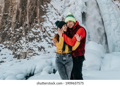 Ein liebendes junges Paar in den Bergen im Winter im Urlaub. Der Mann hat die russische Inschrift Elbrus auf seiner Kappe. Der Typ und das Mädchen reisen. 