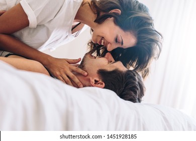 Loving young couple together in bed. Romantic couple about to kiss. - Powered by Shutterstock