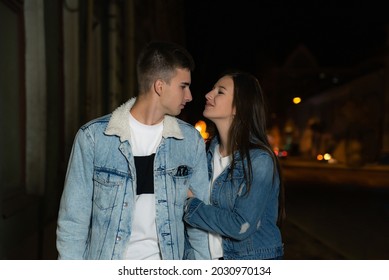 Loving Young Couple Walking On The Street. Young Couple On An Evening Romantic Date. Night City On The Background.