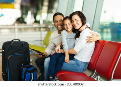 Loving Young Family Waiting For Their Flight At Airport