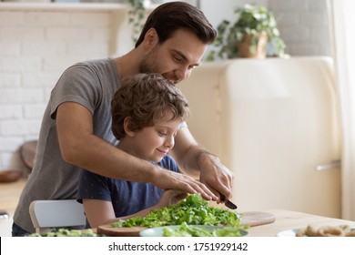 Loving young father teach small preschooler son cooking healthy food breakfast at home, caring dad and little boy child chop vegetables prepare salad in kitchen together, wellbeing, dieting concept - Powered by Shutterstock