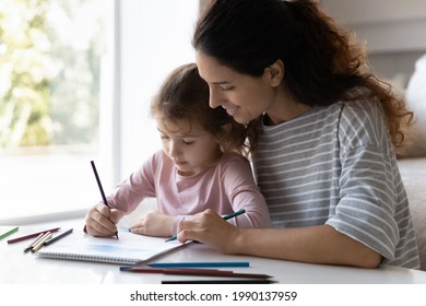 Loving Young Latino Mother And Small Teen Biracial Daughter Drawing Painting Together At Home. Happy Caring Hispanic Mom And Little Ethnic Girl Child Have Fun Play Engaged In Hobby Activity.