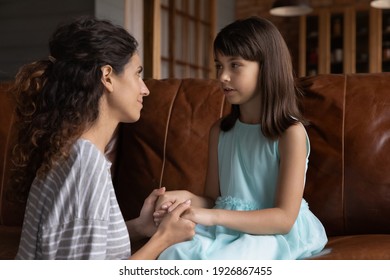 Loving Young Latino Mother Talk Speak With Little 8s Daughter, Help With School Problems. Caring Hispanic Mom Hold Small Girl Child Hands, Comfort Or Caress Kid Show Support. Family Bonding Concept.