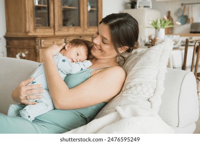 Loving young mom carying of her newborn baby at home. - Powered by Shutterstock