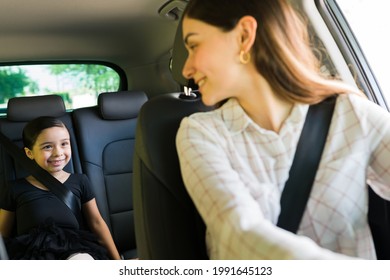 Loving Young Mom Looking Back At Her Daughter In The Car And Talking While Taking Her To A Ballet Lessons And Doing Errands