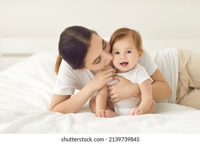 Loving young mother kiss little newborn baby enjoy maternity leave at home. Caring mom cuddle hug small infant child or kid. Mothers day celebration. Happy motherhood or parenthood. Childcare. - Shutterstock ID 2139739845