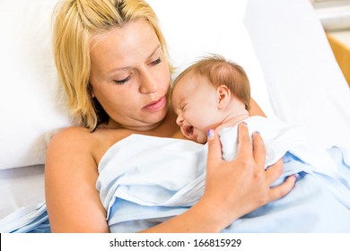 Loving Young Mother Practising Kangaroo Mother Care (skin To Skni Contact)