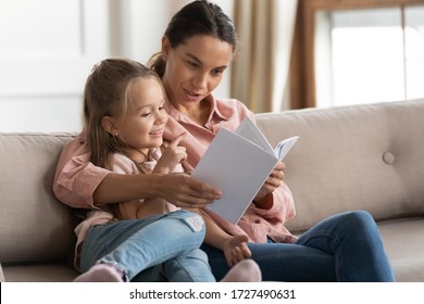 Loving Young Mother Reading Book To Adorable Little Daughter, Sitting On Cozy Sofa In Living Room, Mum Teaching Preschool Girl Child, Family Spending Weekend At Home Together, Children Education