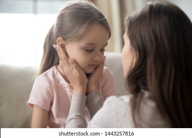 Loving young mother touching upset little daughter face, expressing support, young mum comforting offended adorable preschool girl, showing love and care, child psychologist concept, close up - Shutterstock ID 1443257816