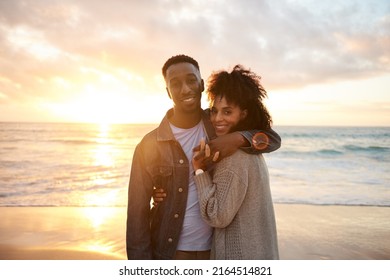 Loving young multiethnic couple smiling on a beach at sunset - Shutterstock ID 2164514821