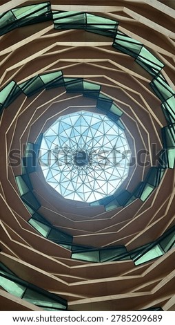 Low angle abstract view of the stunning modern spiraling dome architecture of the Marmara University Faculty of Theology Mosque in Uskudar, Istanbul, Turkey. Features intricate geometric wooden concentric layers and a central glass skylight.