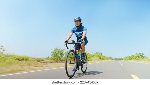 low angle of asian man ride a bicycle on countryside happily - Powered by Shutterstock