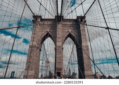 Low angle of brooklyn bridge on a cloudy day in New York City  - Powered by Shutterstock