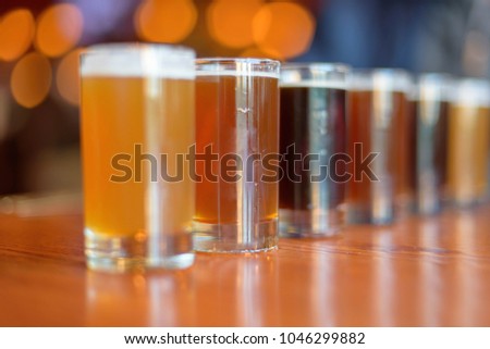Low angle close up of beer flight lined up on the table at a bar