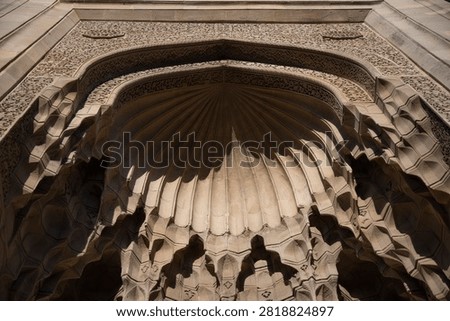  Low angle close up of the medieval Islamic geometric stone carvings and muqarnas stalactites on the Divan-khane portal in Old City Baku, Azerbaijan