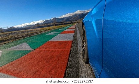 LOW ANGLE, CLOSE UP: Action shot of a brand new luxury car racing on a closed circuit on a perfect sunny afternoon. Metallic blue sportscar speeds along the empty racetrack on an idyllic sunny day.