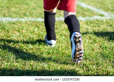 Low Angle Closeup Feet Only Of Kid In Soccer Cleats Running Onto Field