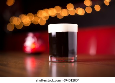 Low Angle Closeup Of Gourmet Old Fashion Craft Cocktail Of Dark Coffee Bourbon Whiskey Drink Garnished By Whipped Egg White Foam On Table Of Red Leather Diner Booth With Blurry Restaurant Background