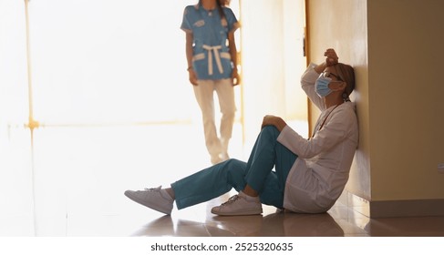 Low angle of exhausted surgeon after long operation sitting in hospital corridor. Bad news, rest after hard operation. Medicine, save life, health concept - Powered by Shutterstock