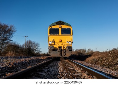 A low angle front point of view of a freight locomotive engine approaching a trespasser on a railway line in an industrial safety image with copy space