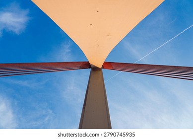 Low angle geometric view looking up at the pylon and red cables of Qiansimen Bridge, Chongqing, China