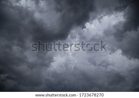 A low angle greyscale of a dark cloudy sky in the evening - perfect for backgrounds and wallpapers