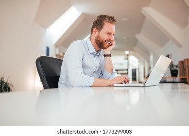 Low Angle Image Of Handsome Smiling Man Using Laptop, Side View, Copy Space.