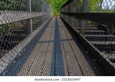 A low angle image of a very old wooden foot bridge with protective metal grating.  - Powered by Shutterstock