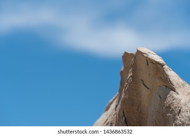 Low angle landscape of one pointed grey rock formation against the sky at Bisti Badlands in New Mexico