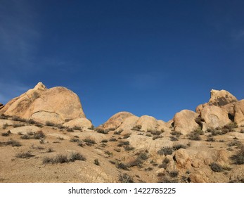 Low angle landscape of various sized rounded boulders in the Alabama Hills in California