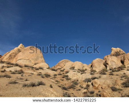 Low angle landscape of various sized rounded boulders in the Alabama Hills in California
