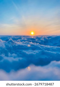 Low angle macro view of snow and ice on frozen lake at sunset
