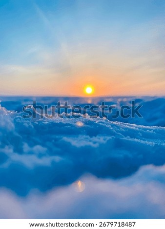 Low angle macro view of snow and ice on frozen lake at sunset